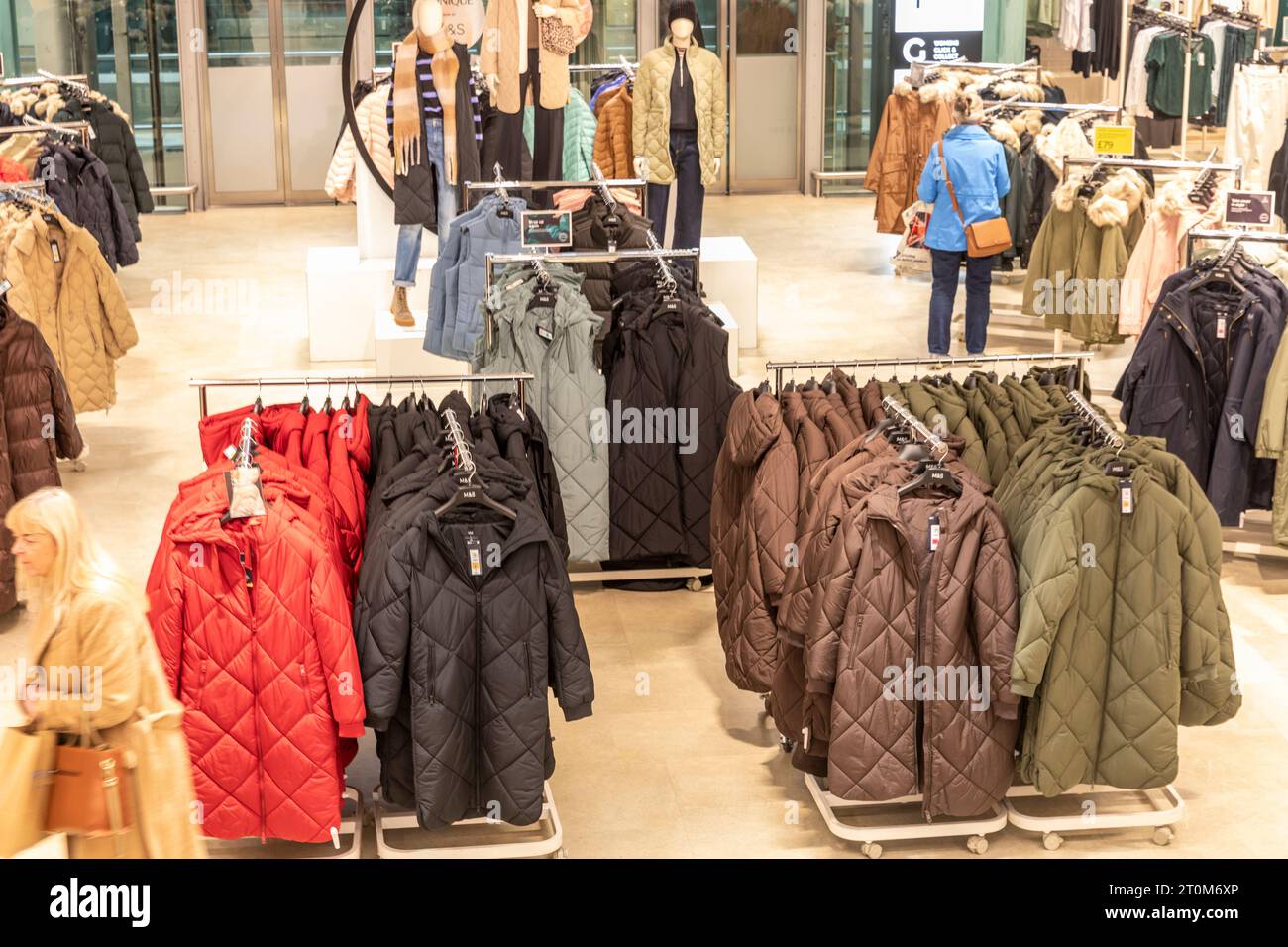 Marks and Spencer magasin intérieur, vêtements pour femmes et manteaux d'hiver à vendre comme deux femmes parcourez les vêtements, Manchester, Angleterre, Royaume-Uni, 2023 Banque D'Images
