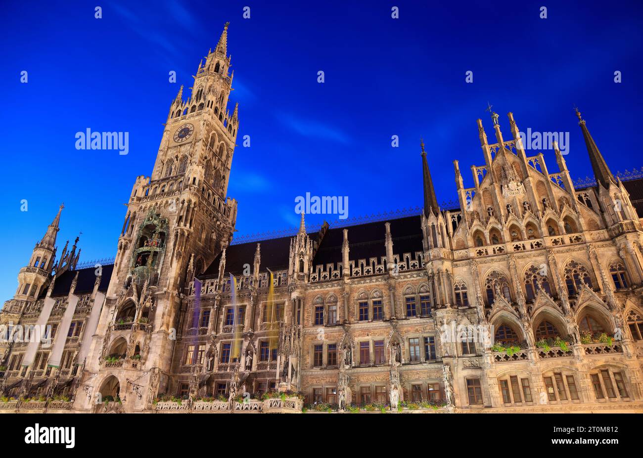 La place de Marie illuminée au crépuscule à Munich, en Allemagne, avec un ancien hôtel de ville et d'autres bâtiments Banque D'Images
