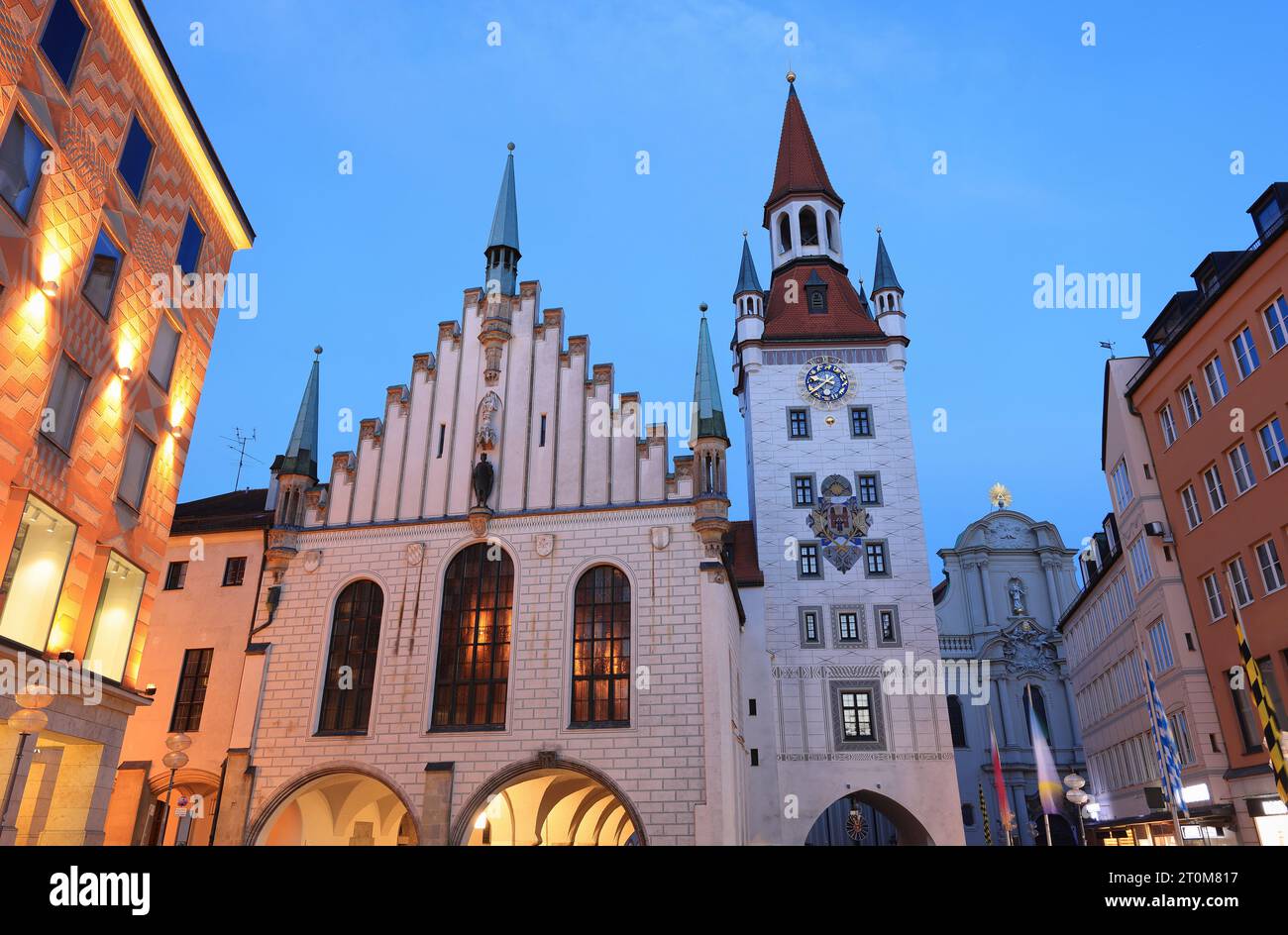 La place de Marie illuminée au crépuscule à Munich, en Allemagne, avec un ancien hôtel de ville et d'autres bâtiments Banque D'Images