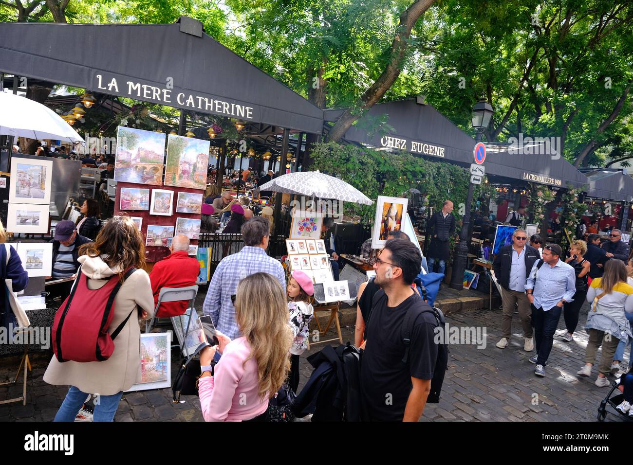 Touristes inspectant des œuvres d'art de divers artistes sur la place Tertre dans le quartier de Montmartre à Paris Banque D'Images