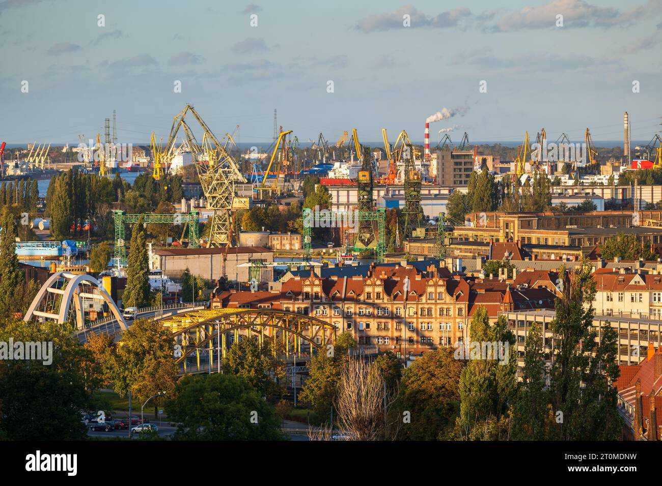 Ville de Gdansk paysage urbain industriel en Pologne, chantier naval de Gdansk avec des grues portuaires historiques emblématiques au coucher du soleil. Banque D'Images
