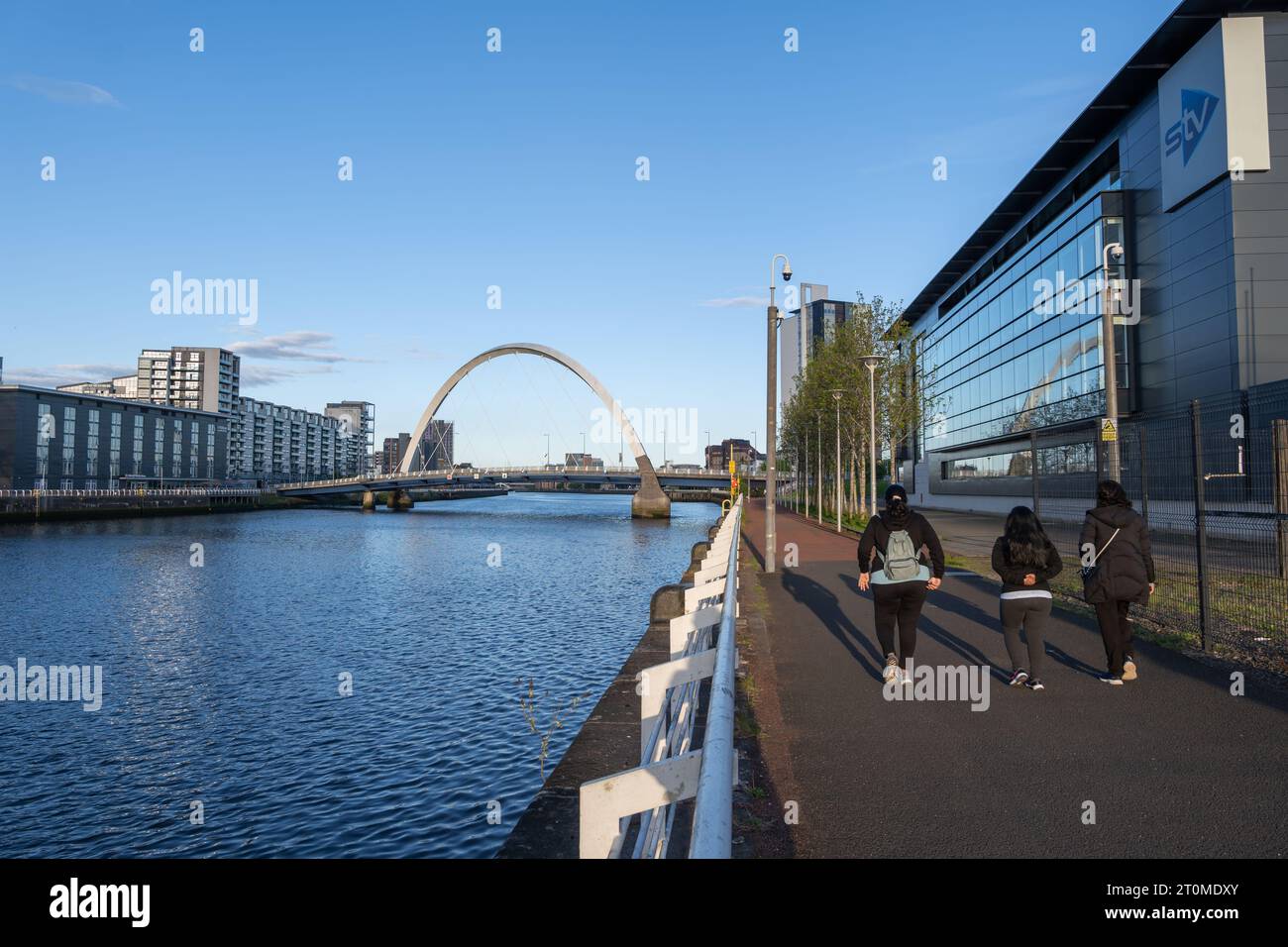 Ville de Glasgow en Écosse, Royaume-Uni. Les femmes se promènent sur la promenade de la rivière Clyde au coucher du soleil avec vue sur le pont Clyde Arc et le bâtiment STV sur la droite. Banque D'Images