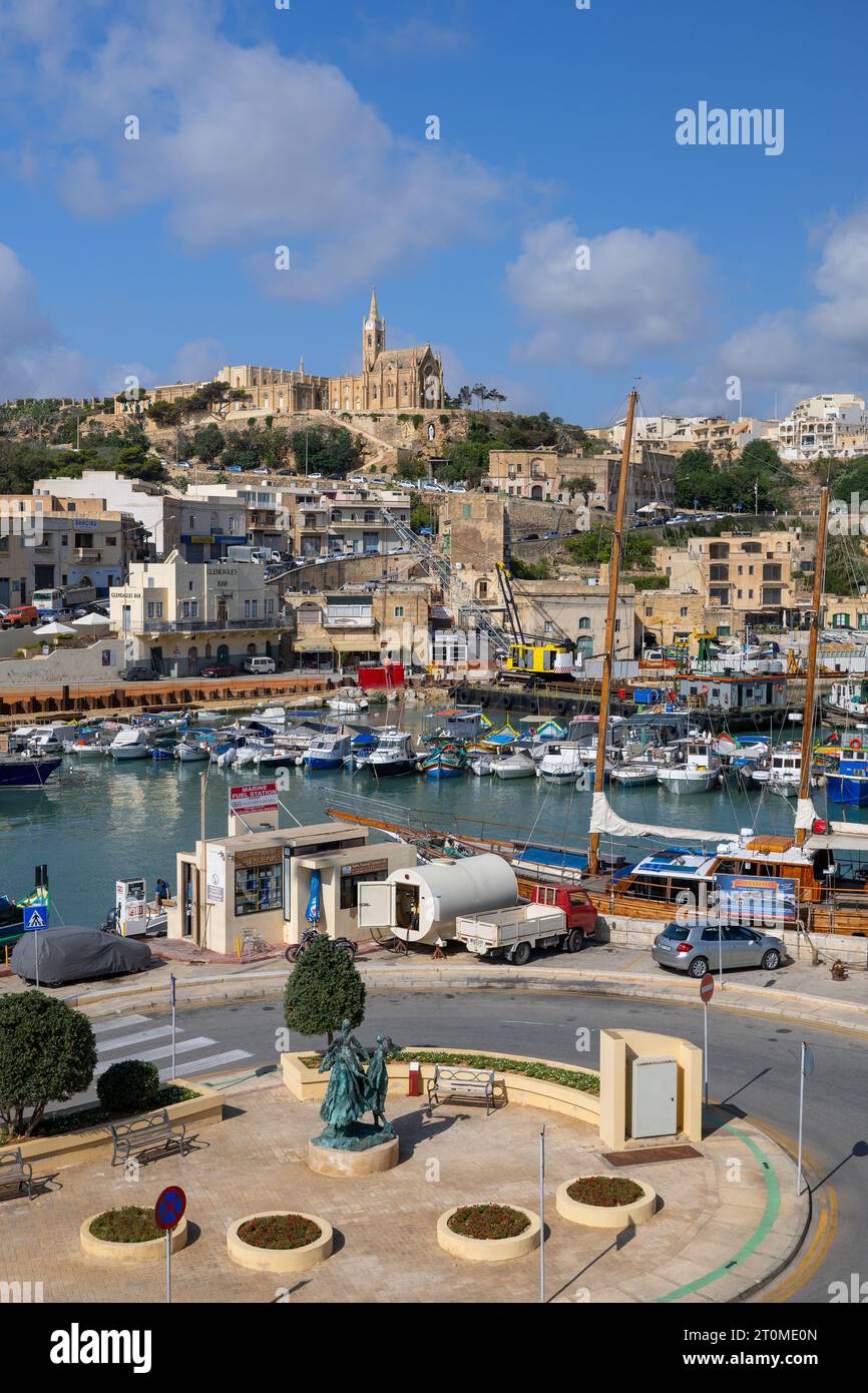 Ville de Mgarr sur l'île de Gozo, Malte, paysage urbain, port et place avec trois Grâces monument. Banque D'Images