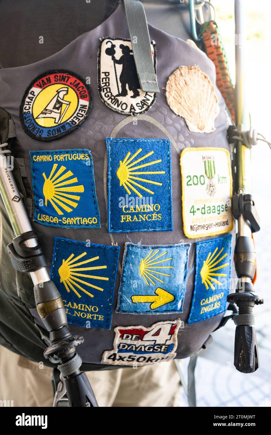 Camino Pilgrim avec sac à dos recouvert de badges camino - Camino Frances, Camino Portugues, Camino del Norte, Camino Ingles Banque D'Images