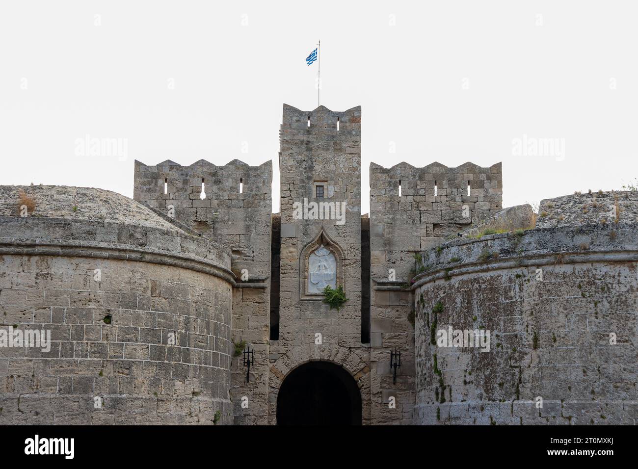 Gros plan de la porte d'Amboise situé dans le coin nord-ouest de la ville médiévale de Rhodes avec drapeau national de la Grèce sur le dessus Banque D'Images