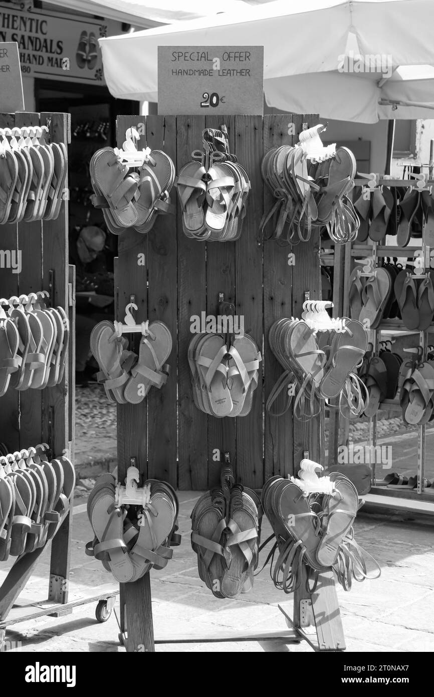 Sandales en cuir faites à la main affichées sur un support en bois à acheter à Rhodes City, Old Town en noir et blanc Banque D'Images