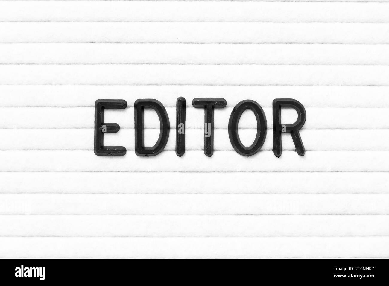 Lettre de couleur noire dans l'éditeur de mot sur fond de panneau de feutre blanc Banque D'Images
