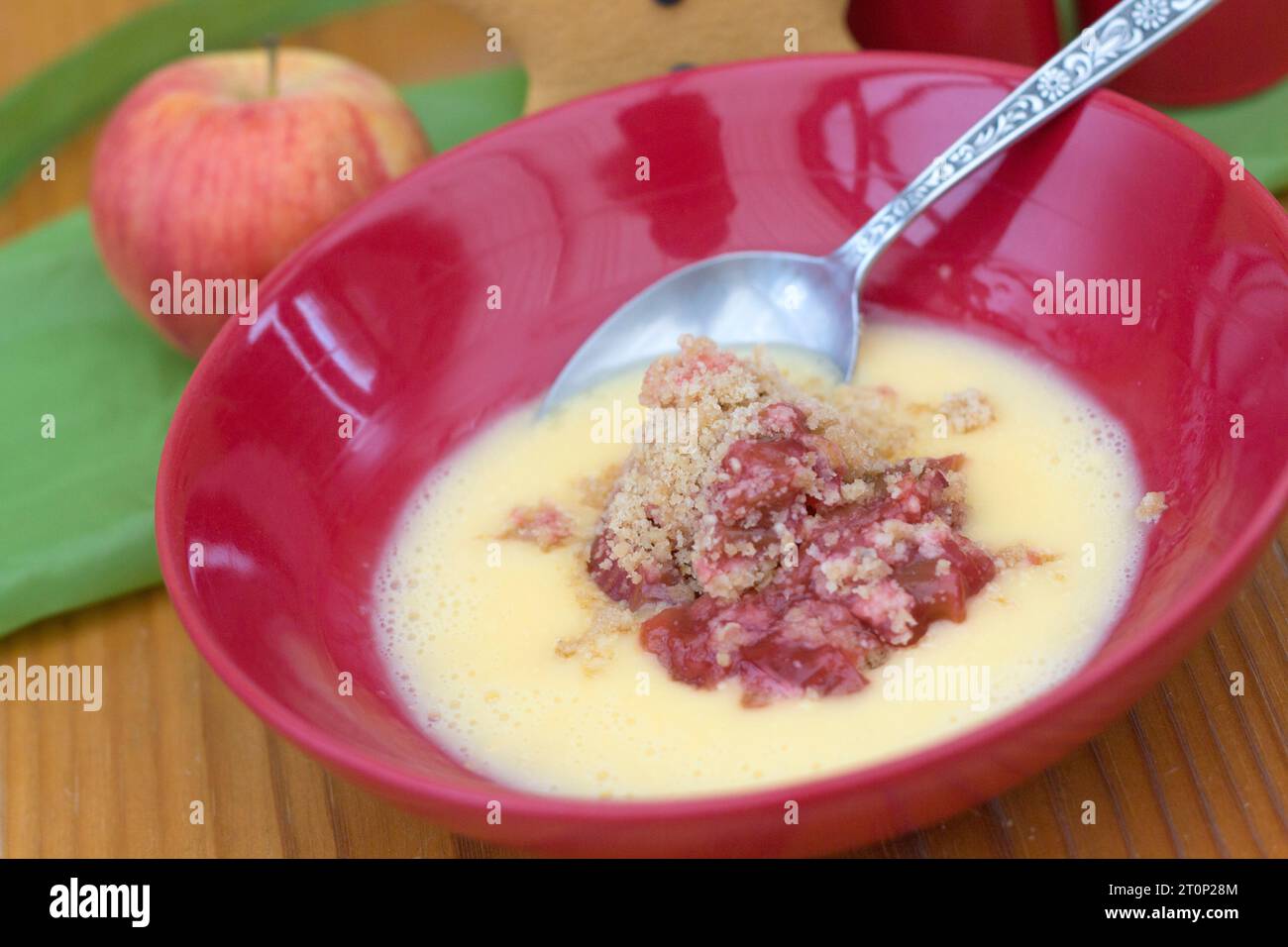 Un plat de crumble à la rhubarbe et aux pommes et un pudding d'hiver à la crème anglaise Banque D'Images