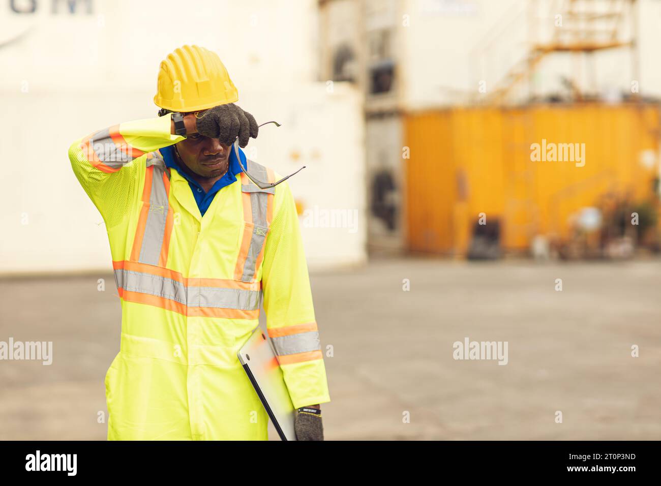 Stress fatigué épuisé travailleur sueur dans la journée chaude en été travaillant à l'extérieur dans le chantier de contrainer d'expédition de port, les gens de race noire africaine. Banque D'Images