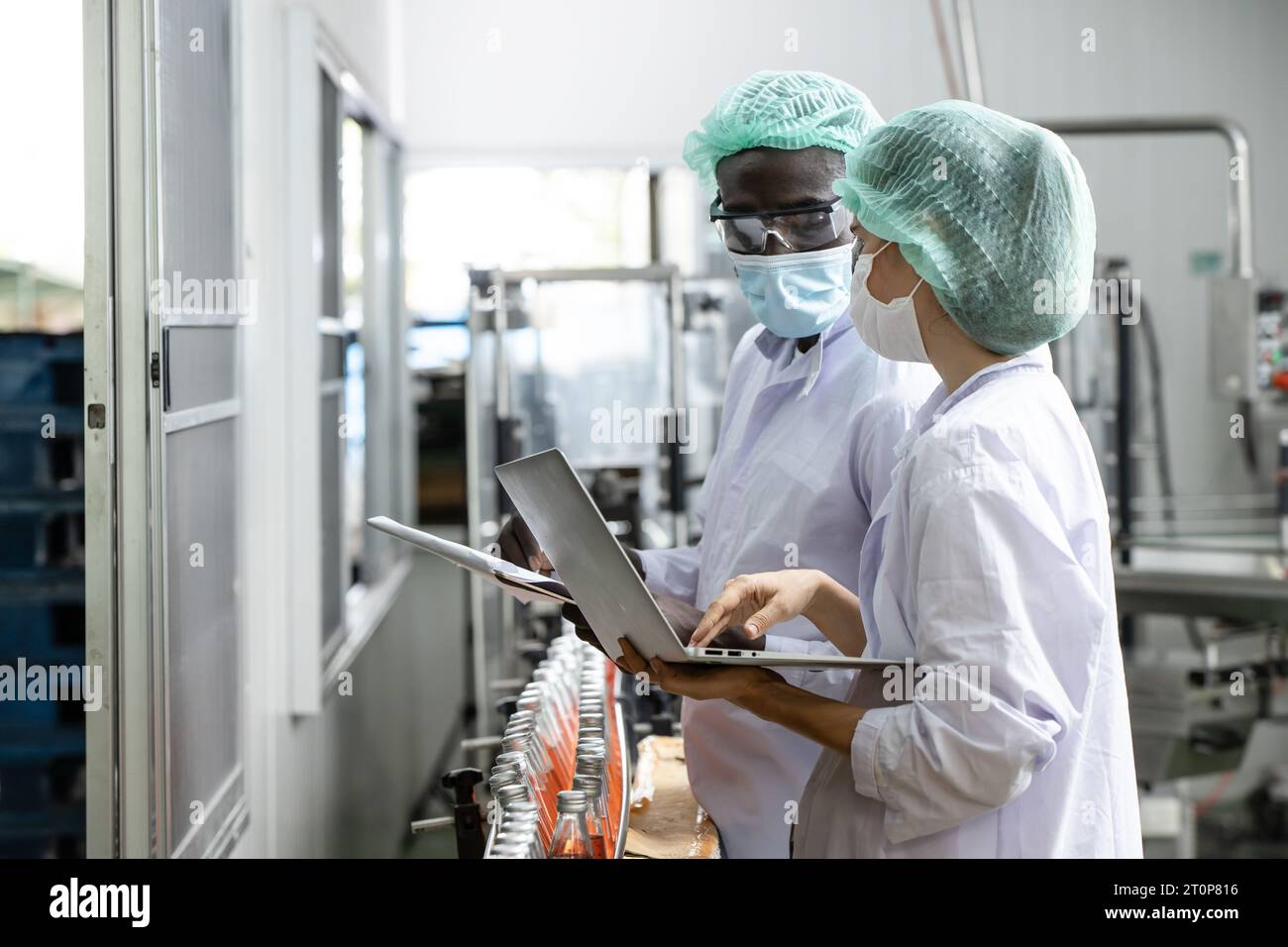 L'équipe de travailleurs de contrôle de la qualité du personnel de contrôle de qualité de l'usine de boissons à boire travaille. Le responsable de l'hygiène vérifie l'inspection des processus standard dans la production de l'usine Banque D'Images