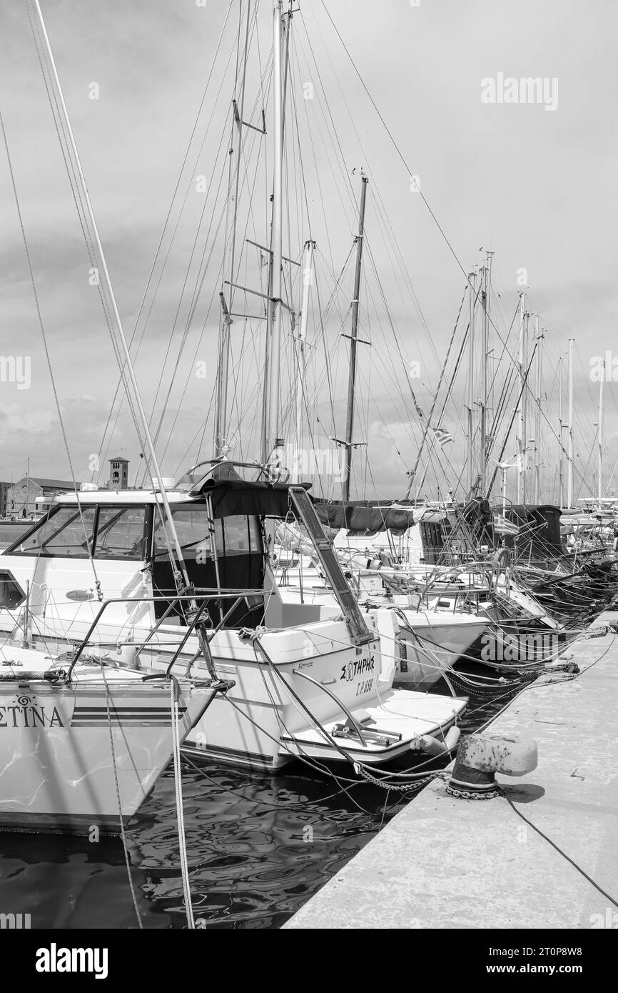 Rangée de yachts amarrés le long du port de Mandraki en noir et blanc Banque D'Images