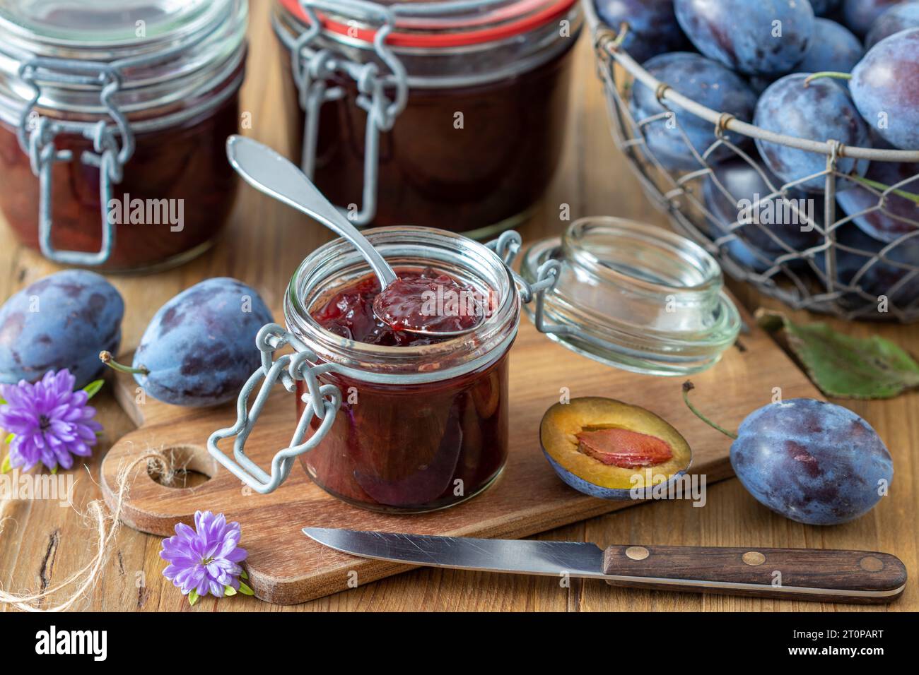 confiture de prunes en verre maison et prunes fraîches en panier Banque D'Images