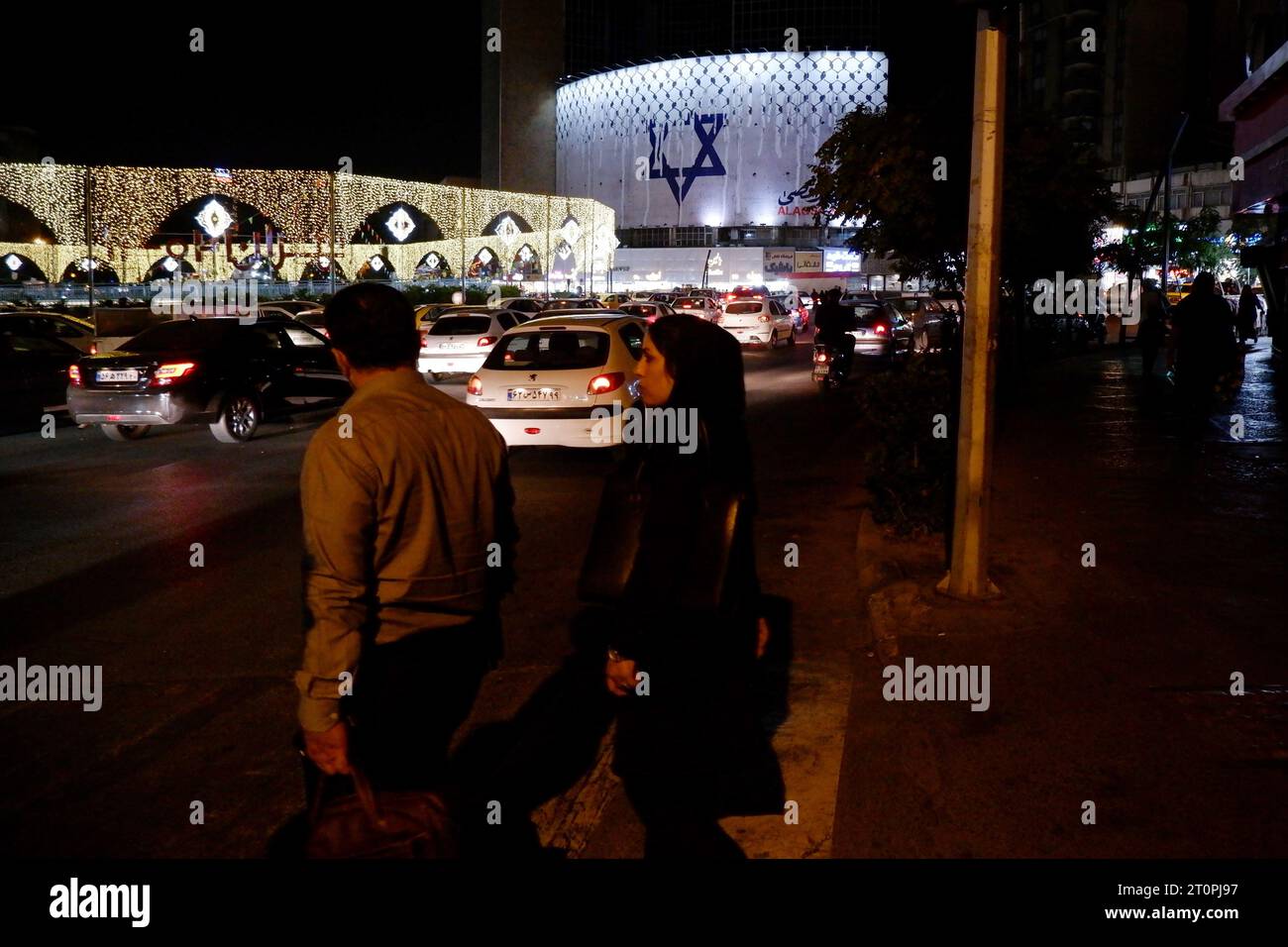 Téhéran, Iran. 8 octobre 2023. Les gens traversent une rue devant un panneau anti-Israël avec le keffiyeh à damiers couvrant l'étoile de David, intitulé ''opération inondation Al-Aqsa'', en solidarité avec les Palestiniens sur la place Vali-ASR, au centre de Téhéran. Depuis des décennies, l'escalade la plus sanglante du conflit israélo-palestinien a vu le Hamas effectuer un barrage de roquettes massif et une opération terrestre, aérienne et maritime le 7 octobre. L'armée israélienne a déclaré avoir tué plus de 200 Israéliens et en avoir blessé 1 000, tandis que des soldats et des civils étaient pris en otage. (Image de crédit : © Rouzbeh Fouladi/ZUMA Press Wire) EDITEUR Banque D'Images