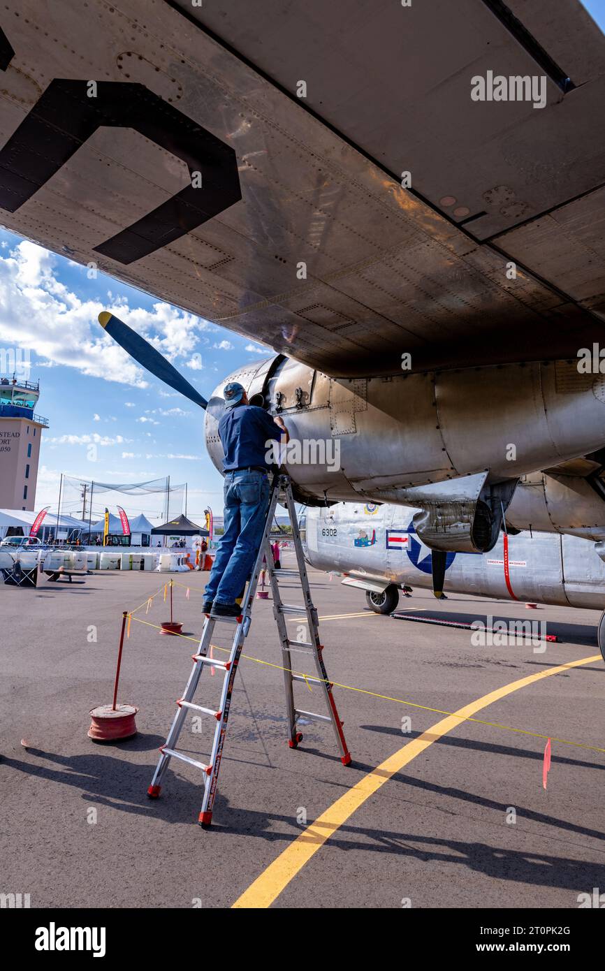 Un homme sur une échelle fait de l'entretien sur un vieil avion Banque D'Images
