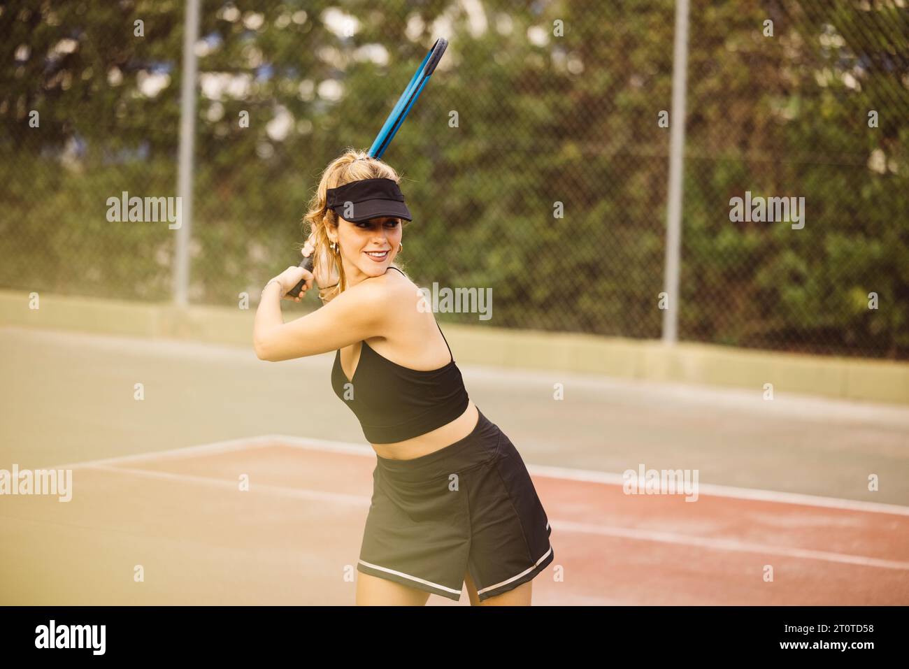 Jeune belle femme jouant un match de tennis. Sportswoman ayant du plaisir à jouer à un jeu de tennis avec des amis. Banque D'Images
