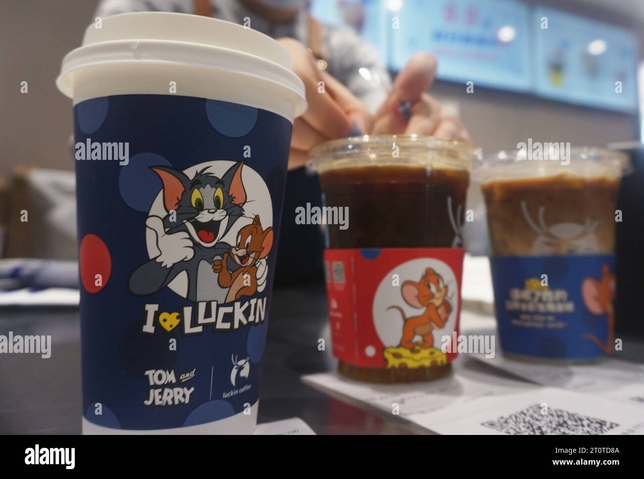 HANGZHOU, CHINE - 9 OCTOBRE 2023 - Un membre du personnel prépare du café mascarpone Latte, qui est une combinaison de Luckin et du dessin animé classique 'Tom et Je Banque D'Images