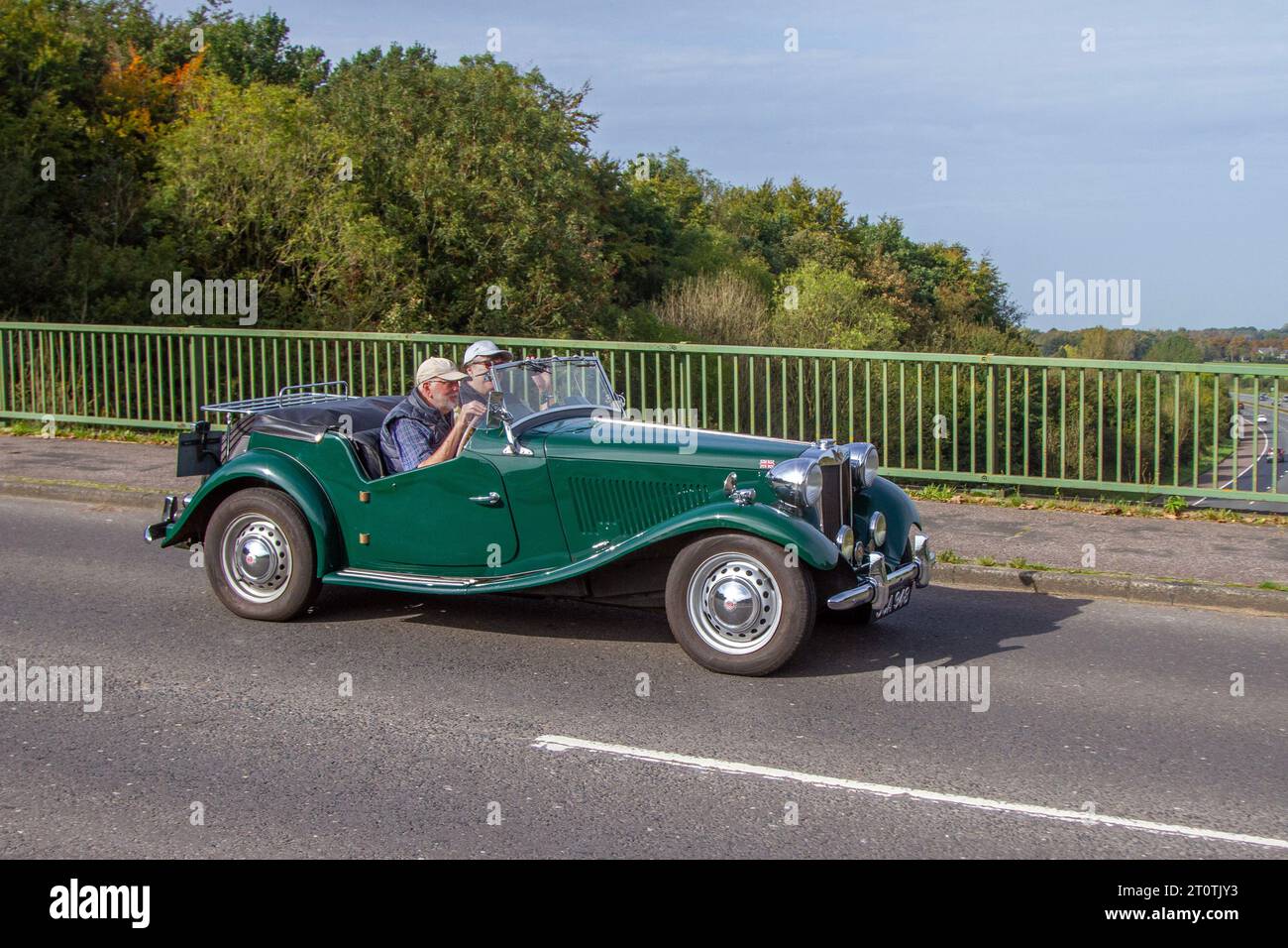 Années 1953 50 cinquante vert British MG TD 1200cc essence roadster roadster, 2 portes, 2 portes, soft-top deux places; véhicule de sport classique et vintage traversant le pont autoroutier dans le Grand Manchester Banque D'Images