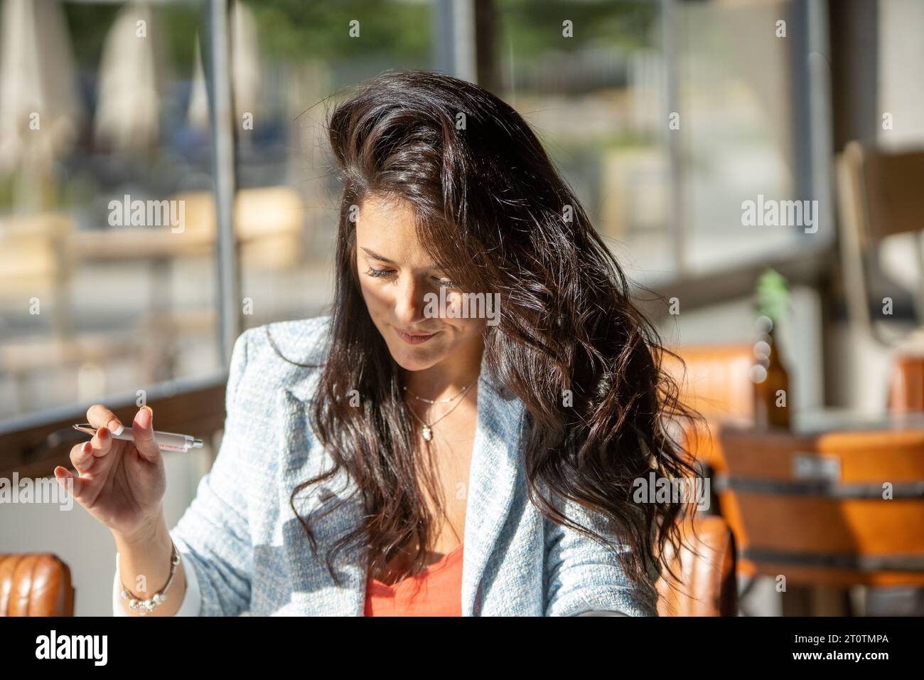 Femme tenant un stylo et utilisant une tablette numérique tout en étant assise dans un café. Concept technologique. Banque D'Images