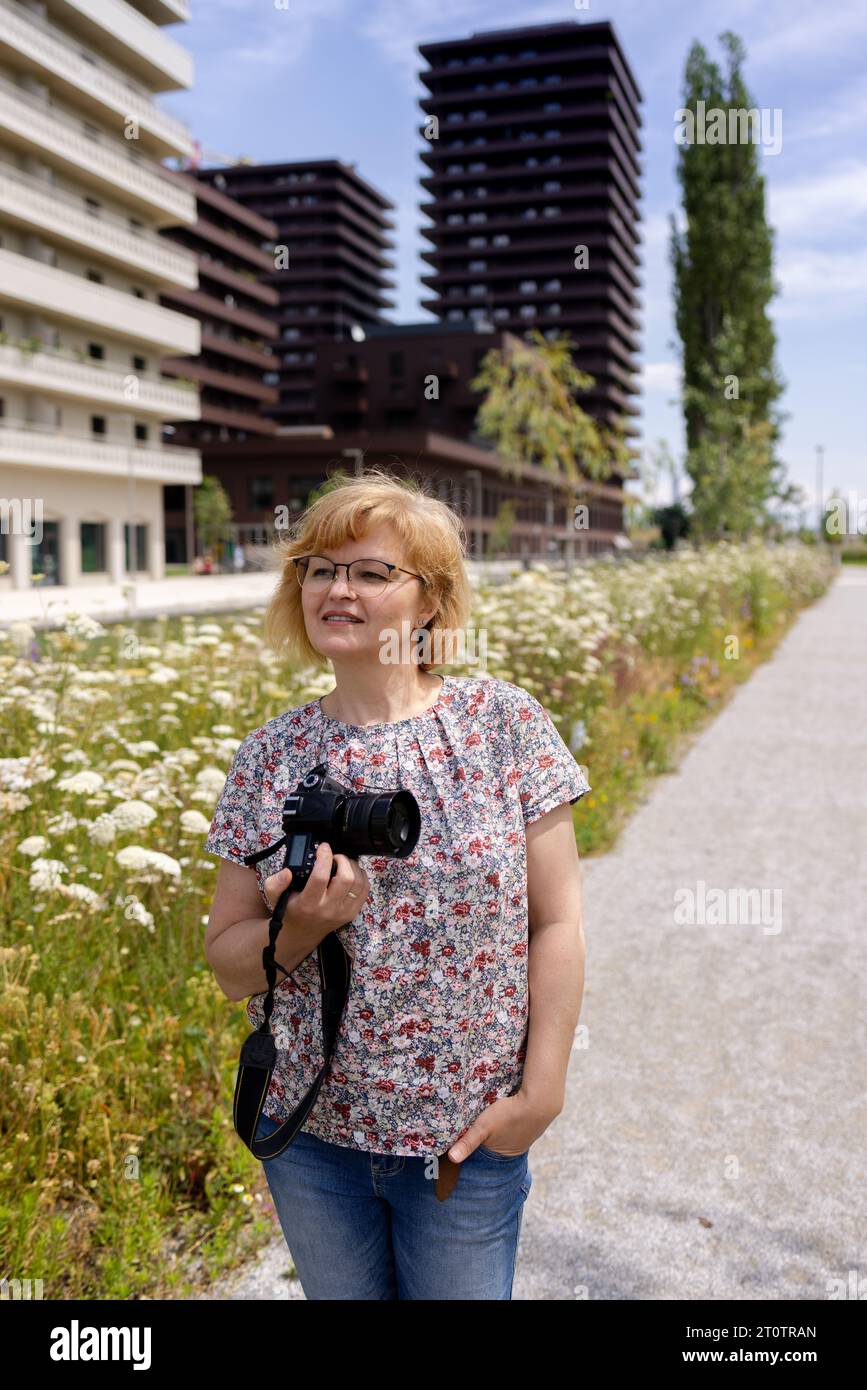 Femme photographe dans la rue d'un nouveau quartier résidentiel Banque D'Images