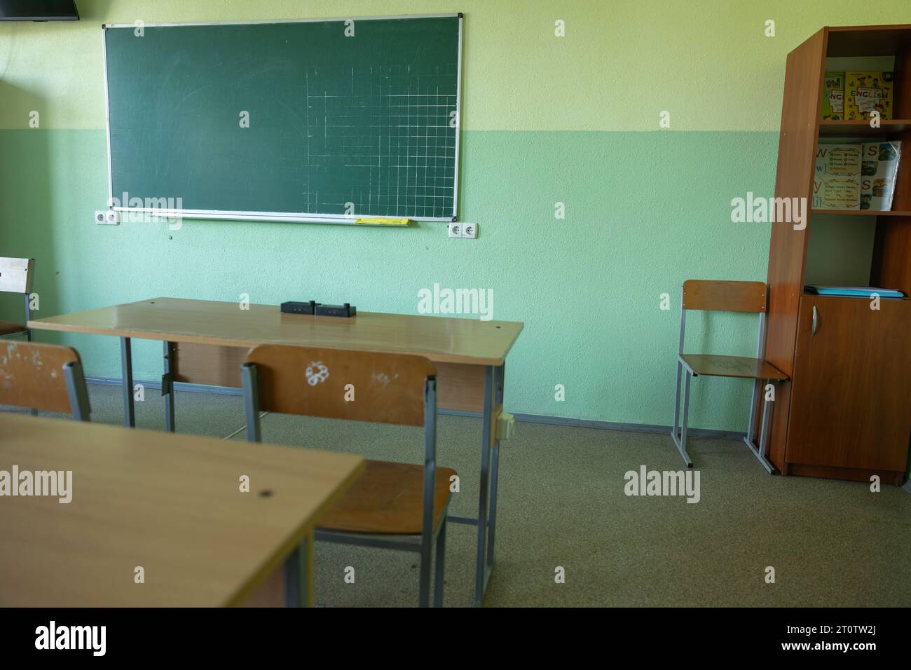 Salle de classe vide sans élèves dans des chaises et des bureaux d'école, conseil en Ukraine. Salle de classe à l'ancienne Banque D'Images