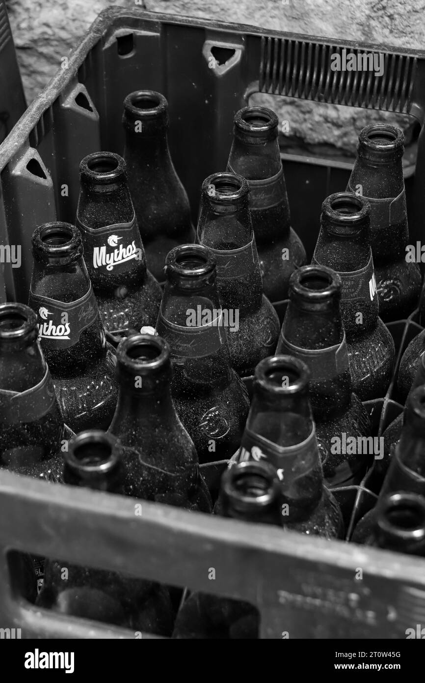 Caisse noire et blanche pleine de bouteilles en verre ouvertes et vides bière Mythos, filiale grecque du groupe Carlsberg Banque D'Images