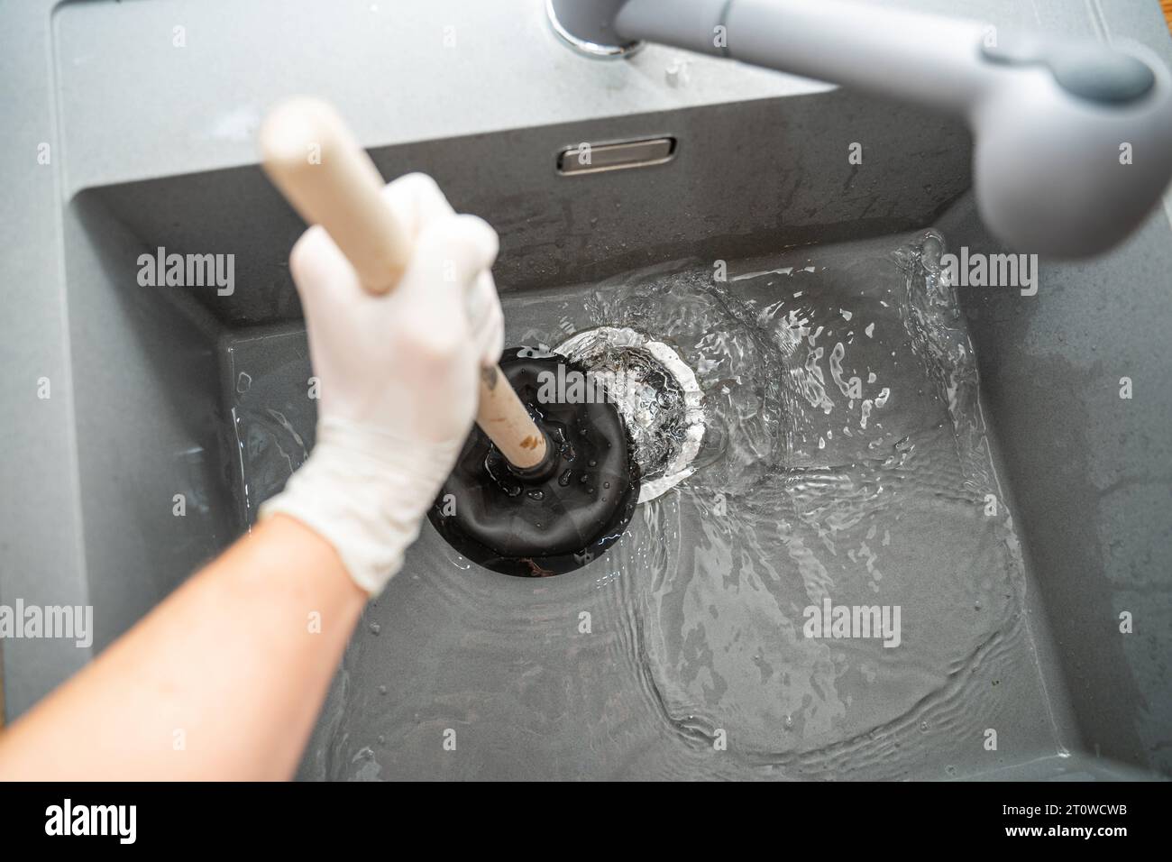 Augsbourg, Bavière, Allemagne. 29 septembre 2023. Workman tente de résoudre un blocage dans un évier avec une cloche d'aspiration *** Handwerker versucht eine Verstopfung in einem Waschbecken mit einer Saugglocke zu lösen Credit : Imago/Alamy Live News Banque D'Images