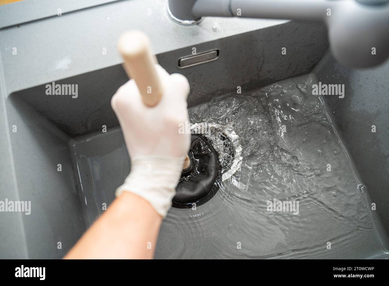 Augsbourg, Bavière, Allemagne. 29 septembre 2023. Workman tente de résoudre un blocage dans un évier avec une cloche d'aspiration *** Handwerker versucht eine Verstopfung in einem Waschbecken mit einer Saugglocke zu lösen Credit : Imago/Alamy Live News Banque D'Images