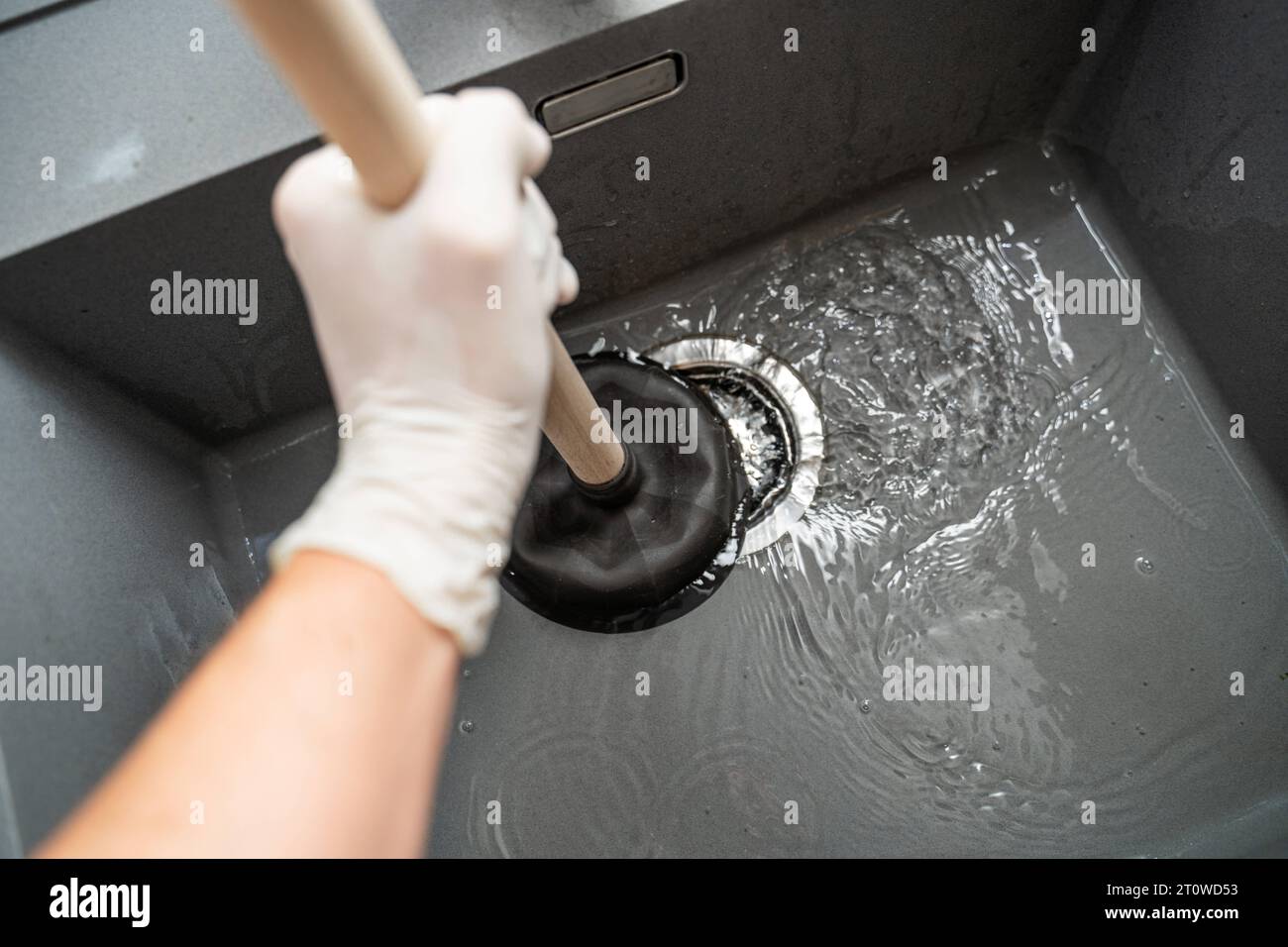 Augsbourg, Bavière, Allemagne. 29 septembre 2023. Workman tente de résoudre un blocage dans un évier avec une cloche d'aspiration *** Handwerker versucht eine Verstopfung in einem Waschbecken mit einer Saugglocke zu lösen Credit : Imago/Alamy Live News Banque D'Images