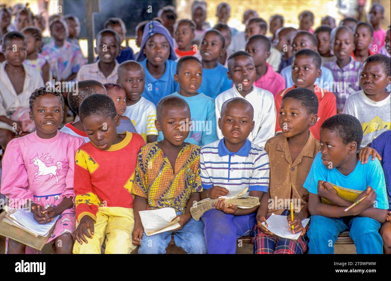 Liberia, Monrovia ; école primaire. Enfants chantant dans une salle de classe à moitié ouverte. Banque D'Images