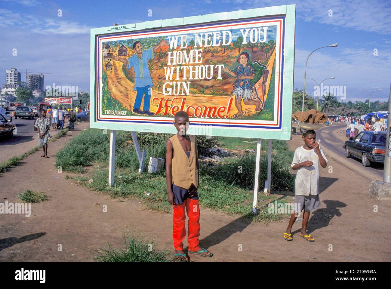 Liberia, Monrovia - des enfants devant un panneau publicitaire pour promouvoir le désarmement et le retour des ex-soldats. Banque D'Images