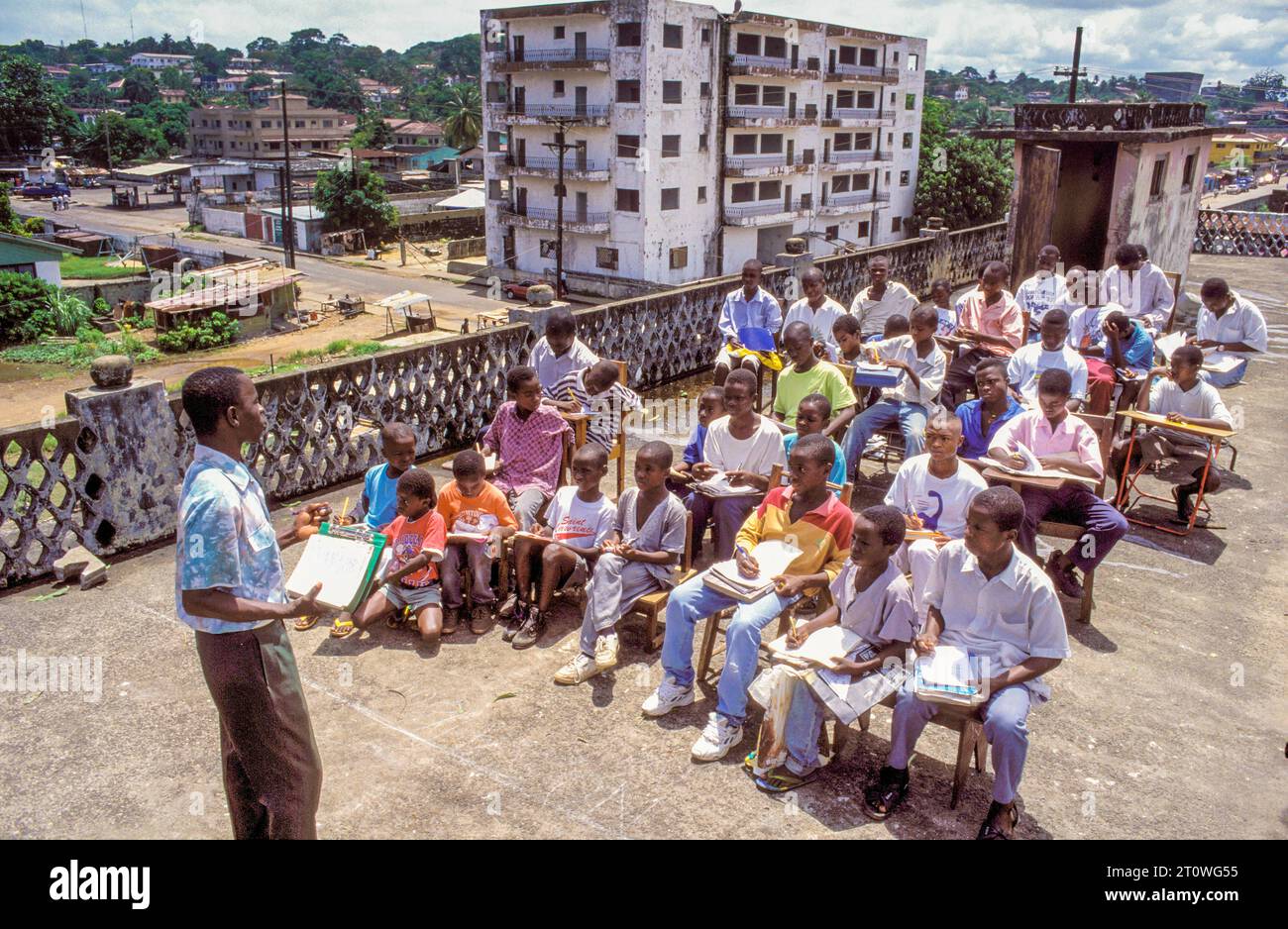 Liberia, Monrovia ; après la guerre civile, ces ex-enfants soldats reçoivent une éducation sur le toit d’un bâtiment scolaire endommagé. Banque D'Images