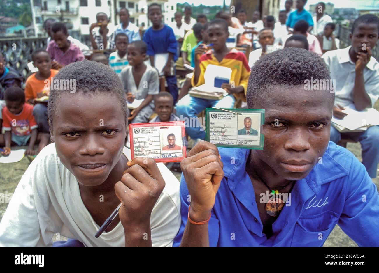 Liberia, Monrovia ; portrait d'ex-enfants soldats montrant leur carte scolaire. Banque D'Images