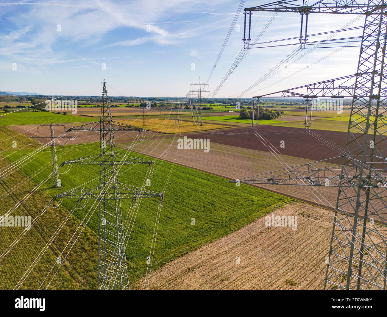 Plan aérien entre plusieurs pylônes électriques avec de nombreuses lignes électriques aériennes et lignes électriques à l'horizon dans la transition énergétique en Allemagne Banque D'Images