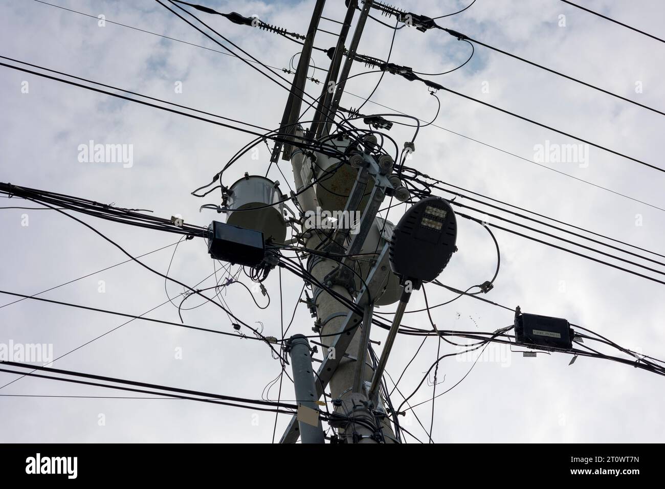 Un poteau téléphonique avec des fils électriques compliqués Banque D'Images