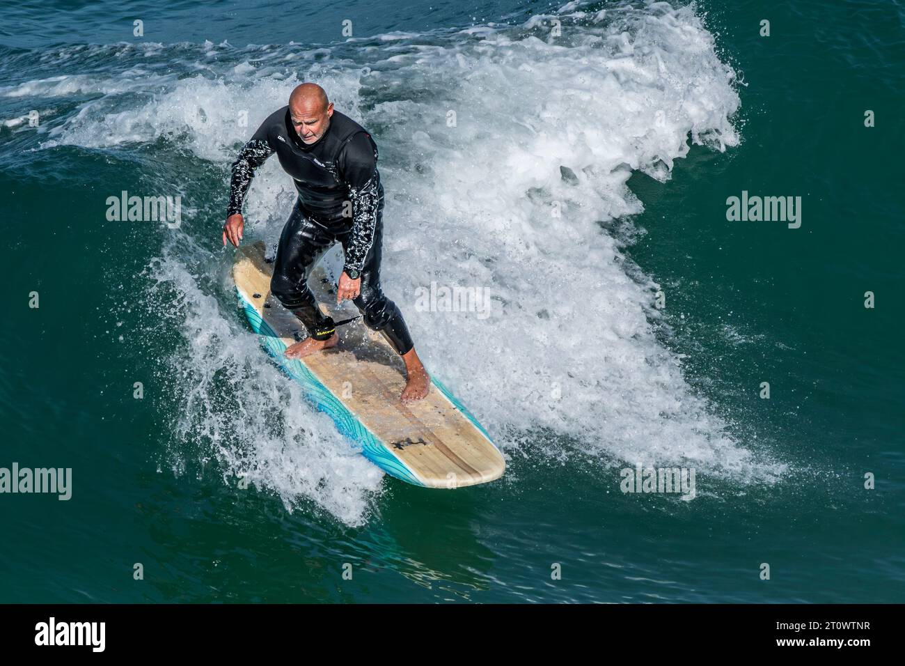 Un surfeur mature chevauchant une vague à Great Western à Newquay en Cornouailles au Royaume-Uni. Banque D'Images