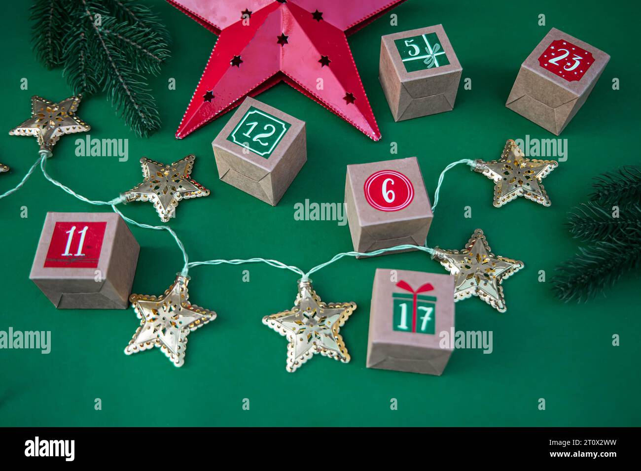 Calendrier de l'Avent fabriqué à la main : cubes de papier artisanal avec des chiffres sur un fond vert vibrant. Tradition de Noël et décoration festive Banque D'Images
