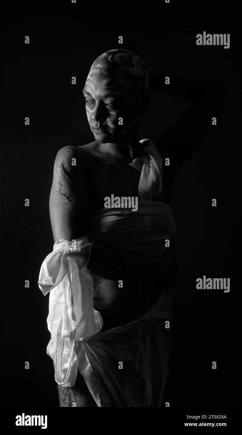 Femme rasée à tête et marquée dans un éclairage discret présentant l'abus des femmes noires. Banque D'Images