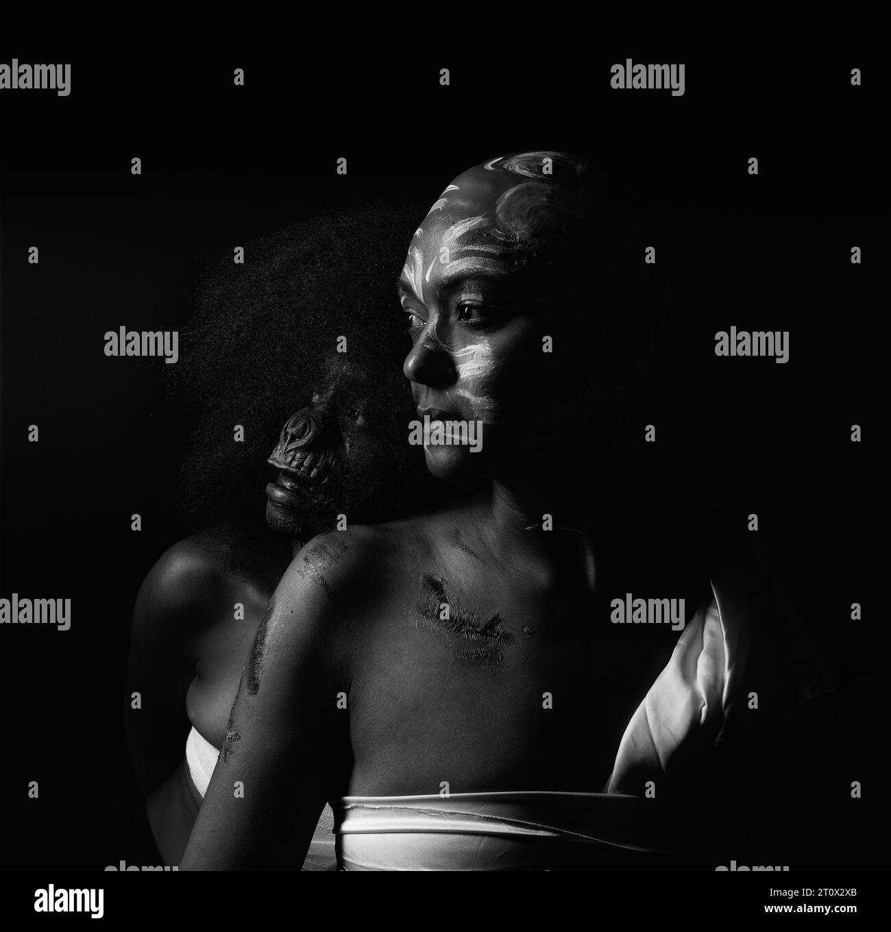 Image studio discrète de mère et fille en maquillage de cicatrices et visage de singe représentant l'abus des femmes noires au fil des ans monochrome Banque D'Images