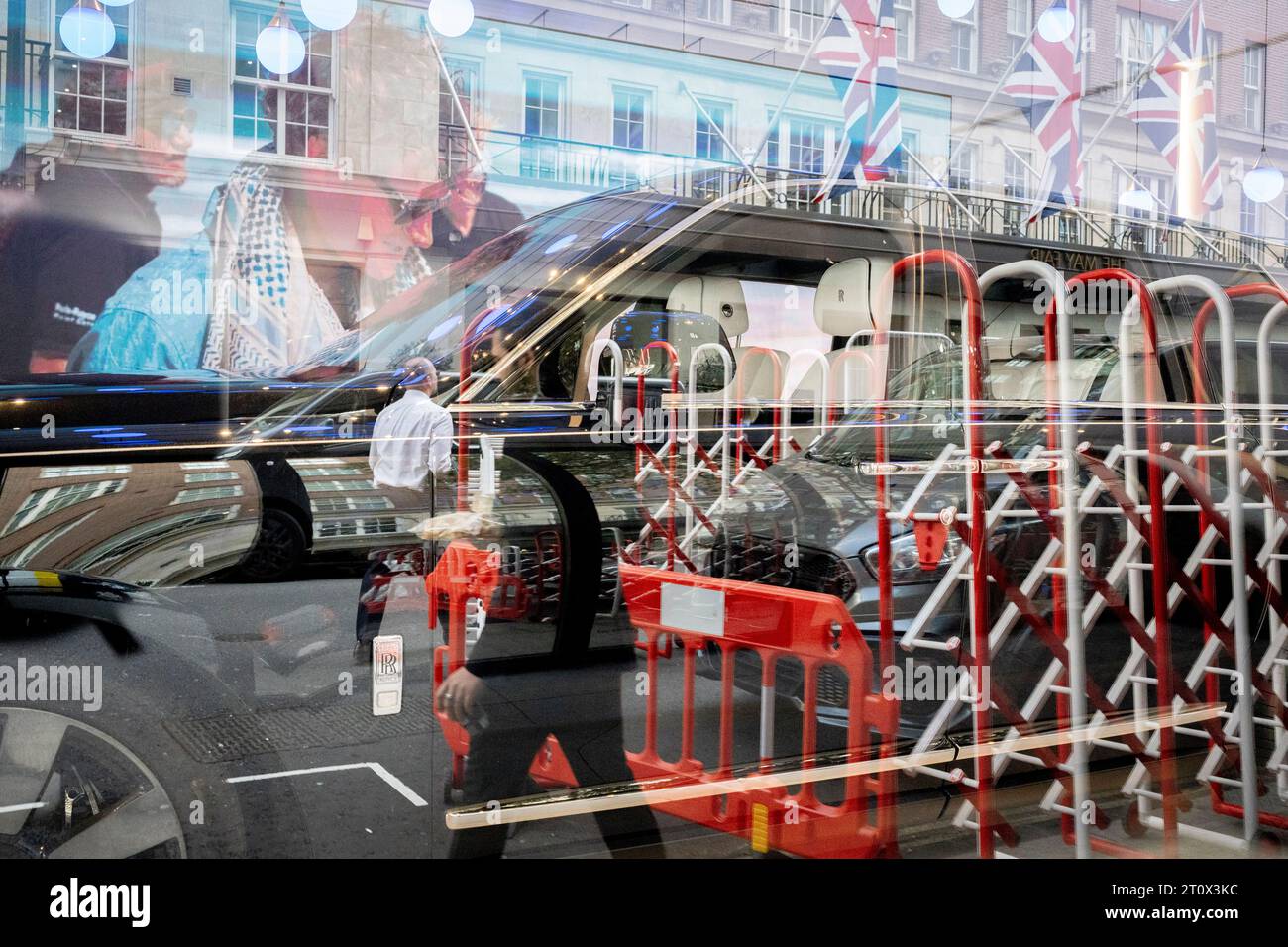 Des membres du public passent devant la fenêtre du showroom Rolls-Royce à Mayfair où un modèle "fantôme" est exposé dans la fenêtre de la concession, le 9 octobre 2023, à Londres, en Angleterre. Banque D'Images