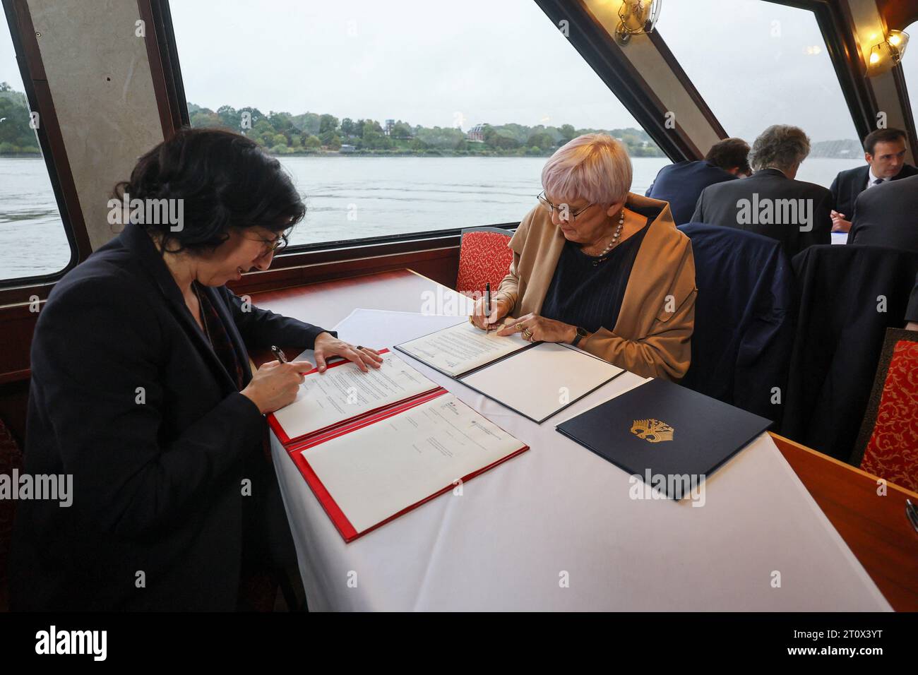 Hambourg, Allemagne. 09 octobre 2023. Claudia Roth (Bündnis 90/Die Grünen, r), ministre d'État à la Culture et aux médias, et Rima Abdul Malak, ministre française de la Culture, signent des documents lors d'une croisière dans le port de Hambourg. Les cabinets allemand et français se réunissent dans la ville hanséatique pour une retraite de deux jours. Crédit : Wolfgang Rattay/Reuters/Pool/dpa/Alamy Live News Banque D'Images