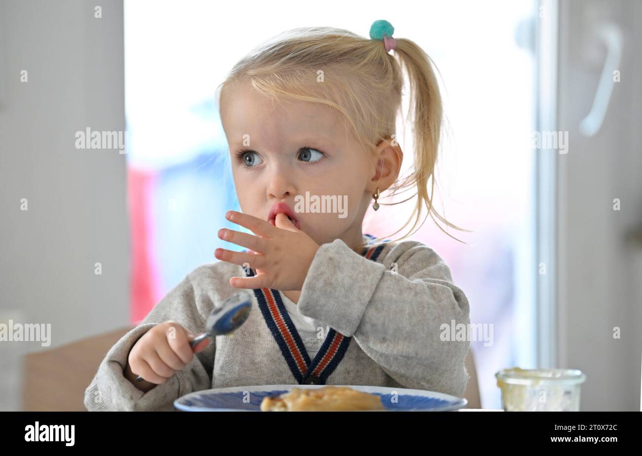 Petite fille, 2 ans, blonde, mange des crêpes, crêpe, assiette, cuillère, manger, Stuttgart, Baden-Wuerttemberg, Allemagne Banque D'Images