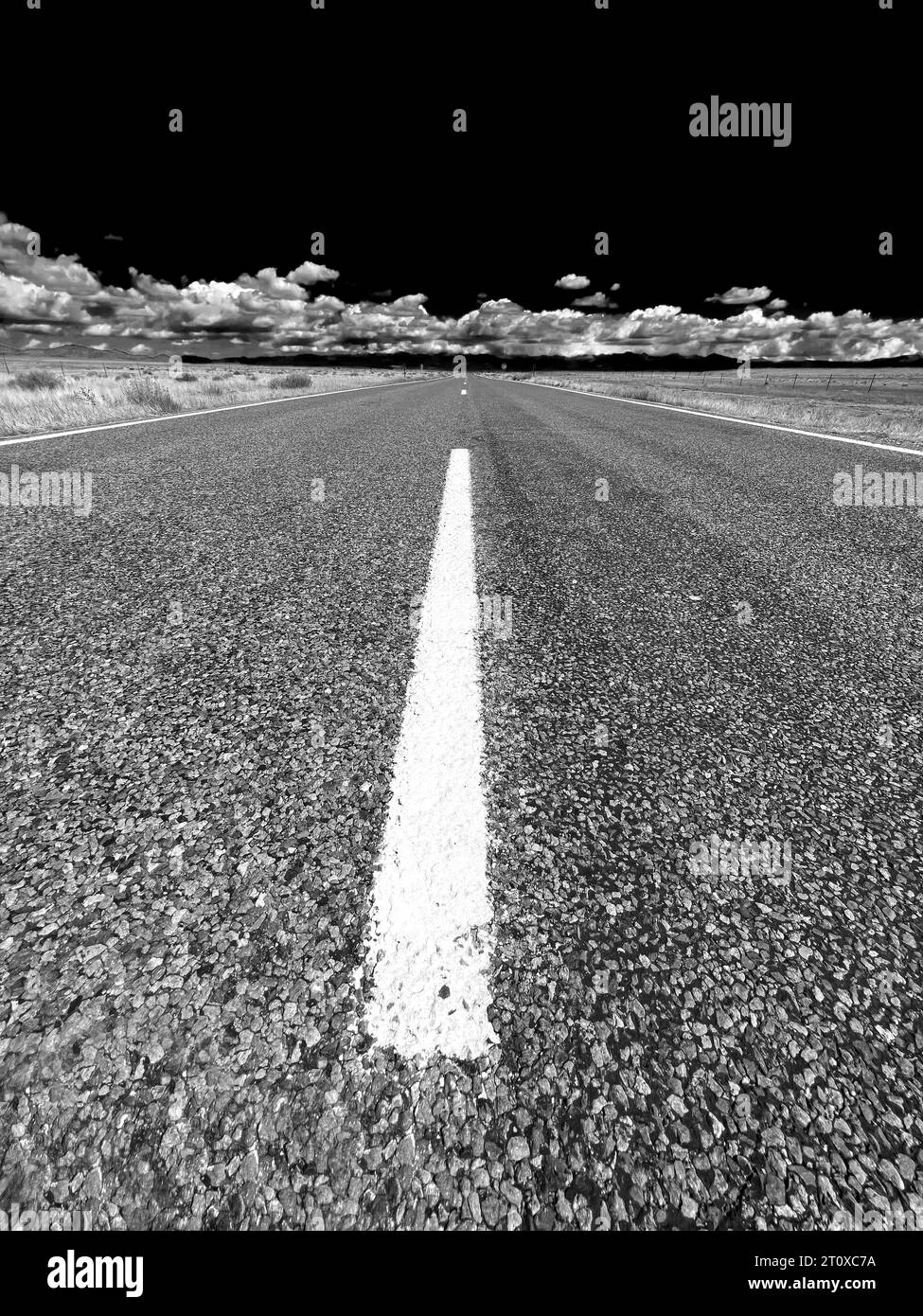 Photographie dramatique en noir et blanc d'une route rurale vide Banque D'Images