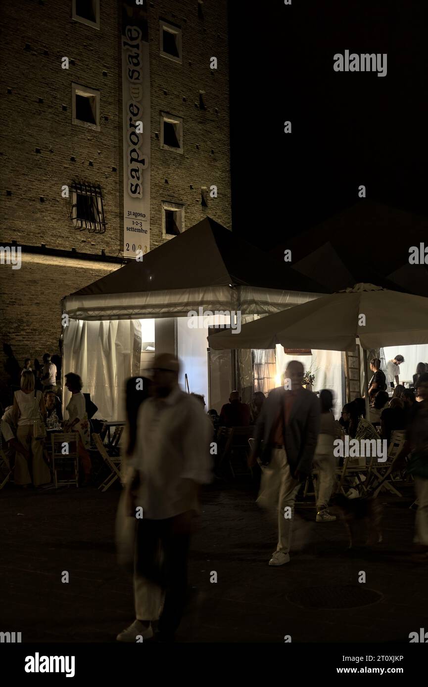 Foire avec des stands et des gens qui passent dans une ville italienne la nuit Banque D'Images