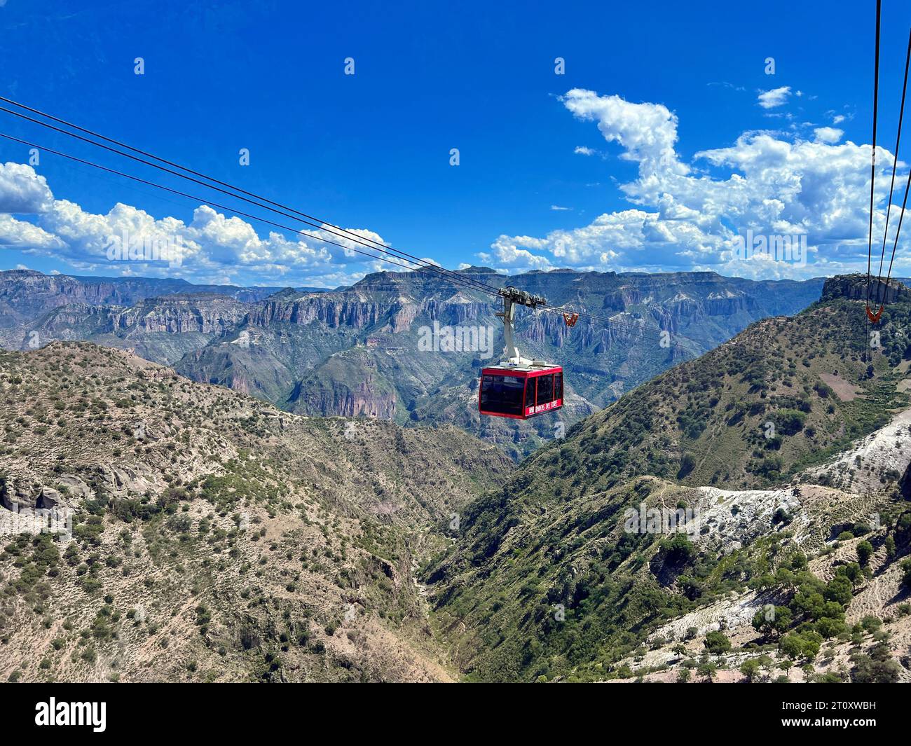 Un balayage panoramique de Copper Canyon, avec un téléphérique orné de 'Bienvenidos a Chihuahua' et 'Barrancas del Cobre' accueillant les touristes, comme eux Banque D'Images