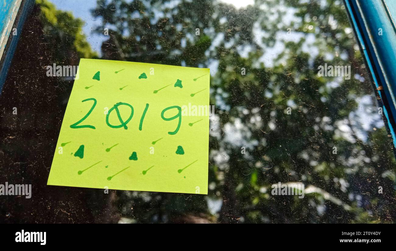 2019 photo de texte avec du papier vert sur fond de verre de fenêtre de maison Banque D'Images