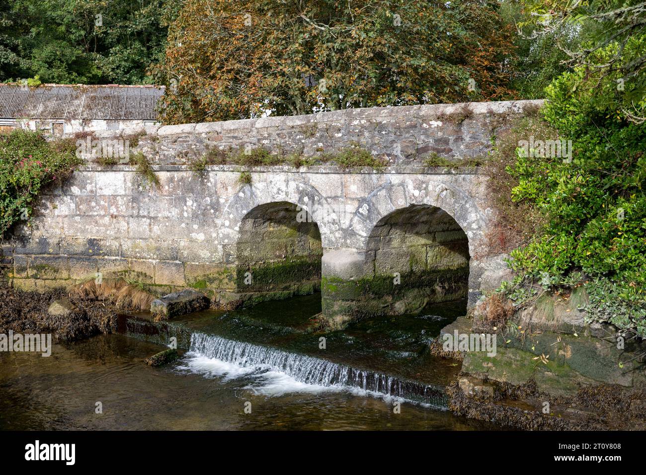 Village de Gweek en Cornouailles, estuaire de Telford coule sous le vieux pont en pierre à deux arcs, Angleterre, Royaume-Uni, septembre 2023 Banque D'Images