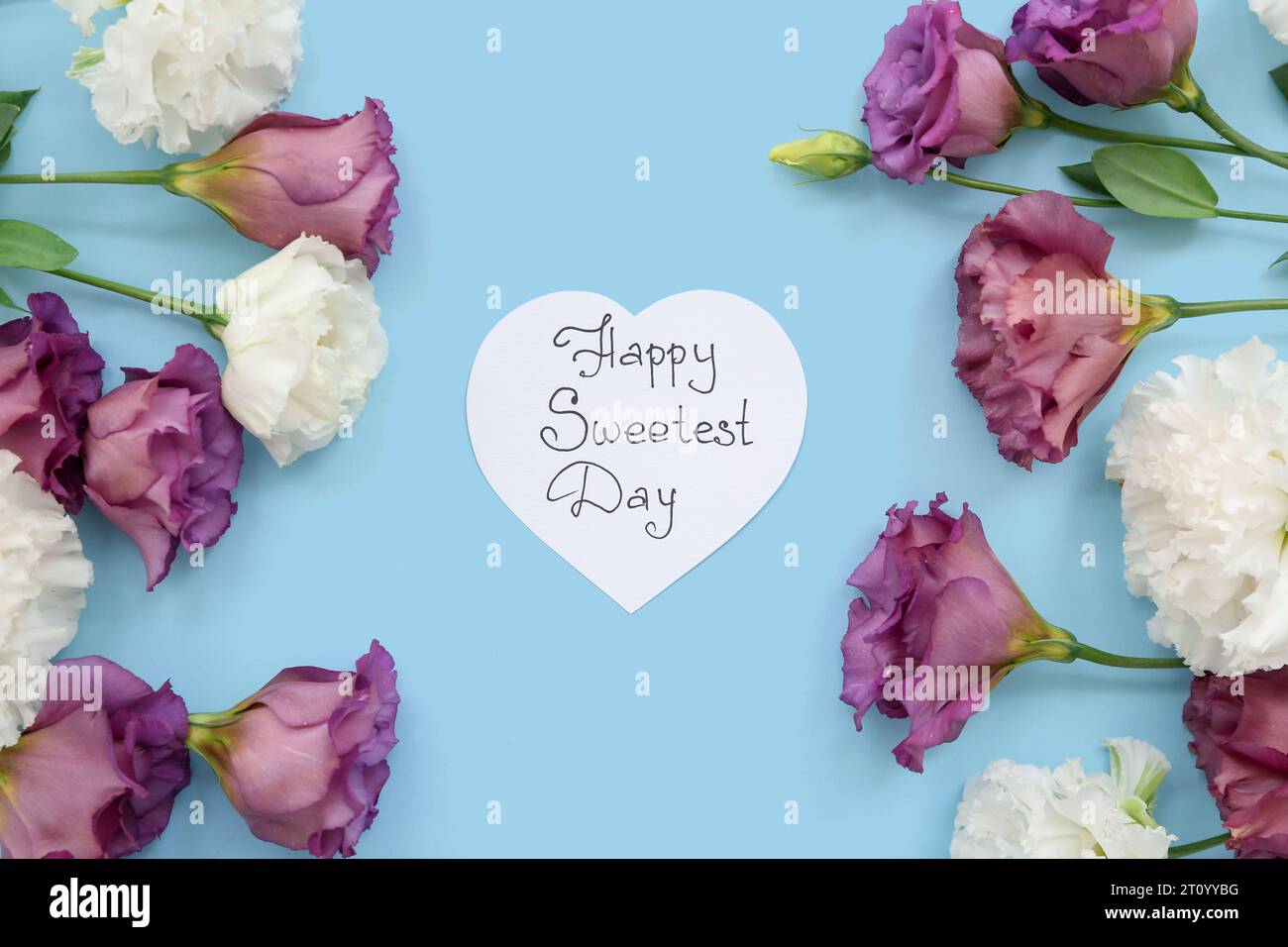 Carte avec texte HAPPY SWEETEST DAY et roses sur fond bleu Banque D'Images