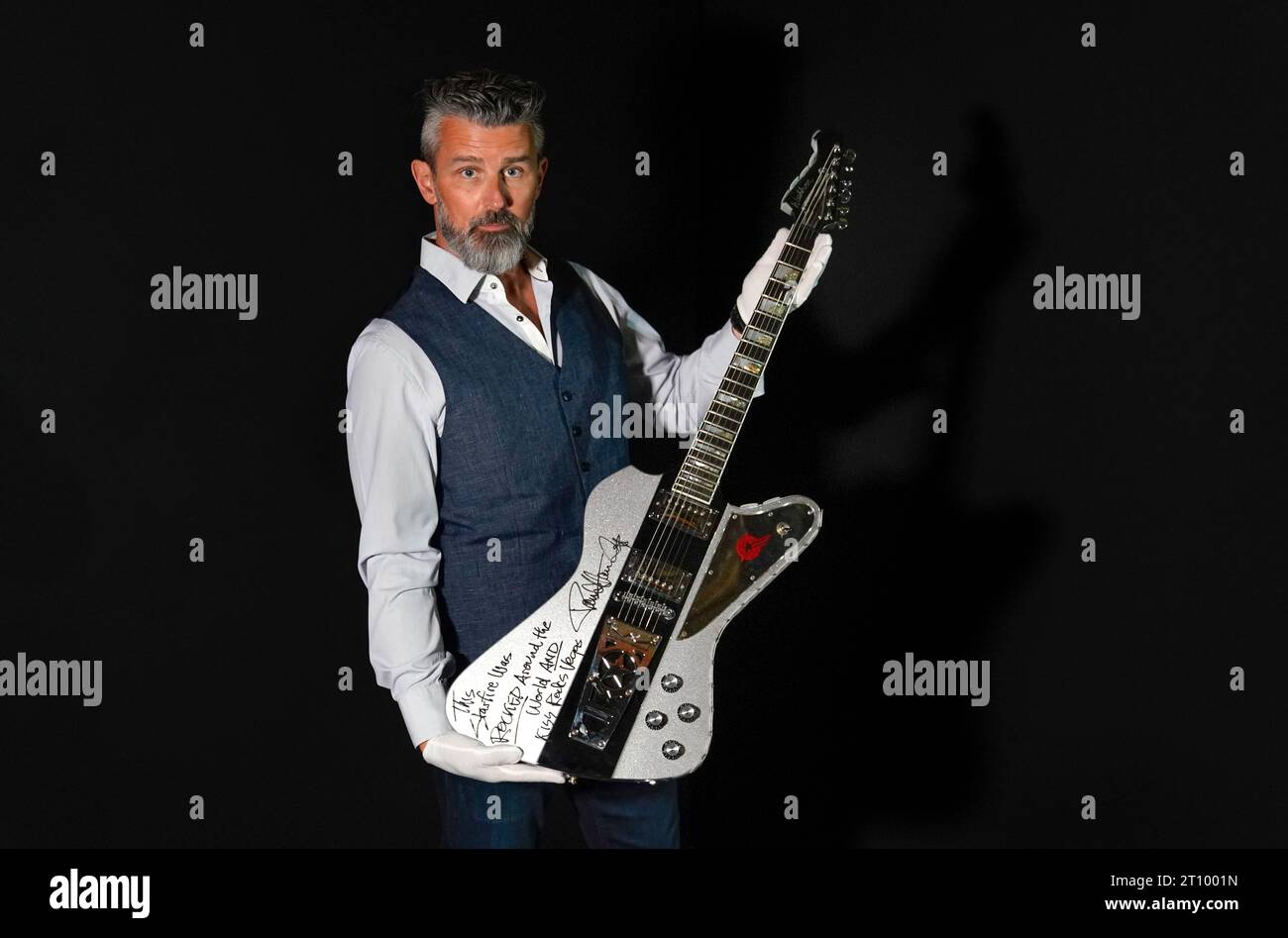 Stephen Lane, PDG de Propstore, tient un Paul Stanley de KISS autographié et inscrit sur scène, utilisé sur mesure la guitare Washburn StarFire à paillettes argentées (estimation de £40 000 - 80.000) lors d'une avant-première pour la Entertainment Memorabilia Auction, au Propstore de Rickmansworth, Hertfordshire. Date de la photo : mercredi 20 septembre 2023. Banque D'Images