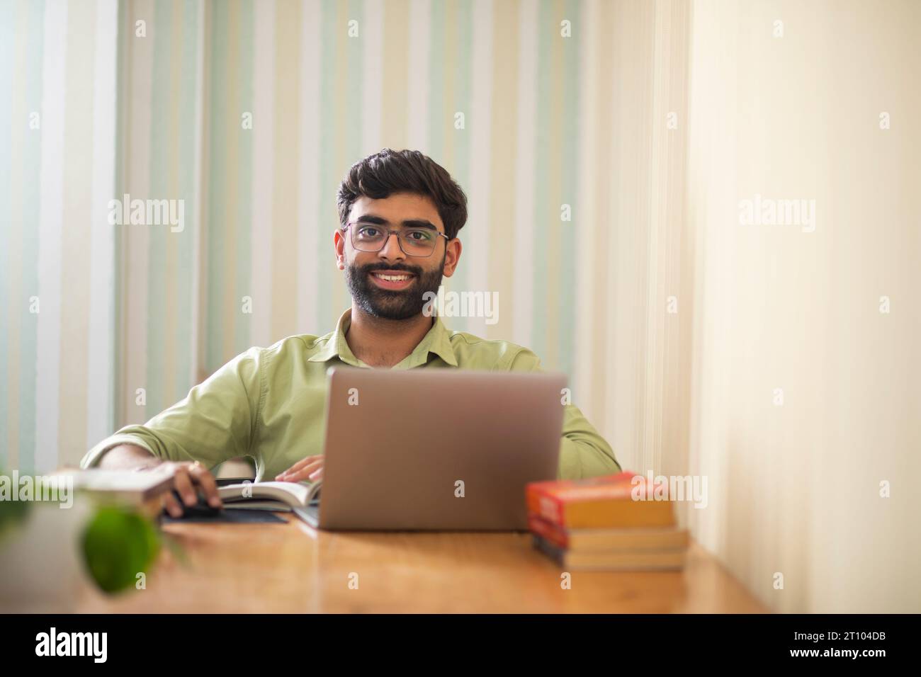 Jeune homme travaillant avec un ordinateur portable dans son bureau à domicile Banque D'Images