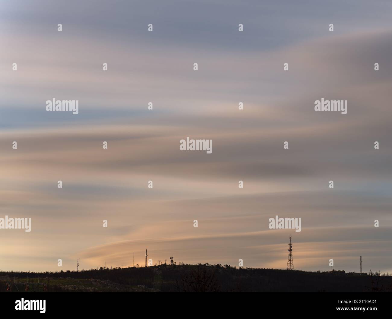 Longue exposition du pic de montagne plat avec antennes de communication au coucher du soleil Banque D'Images